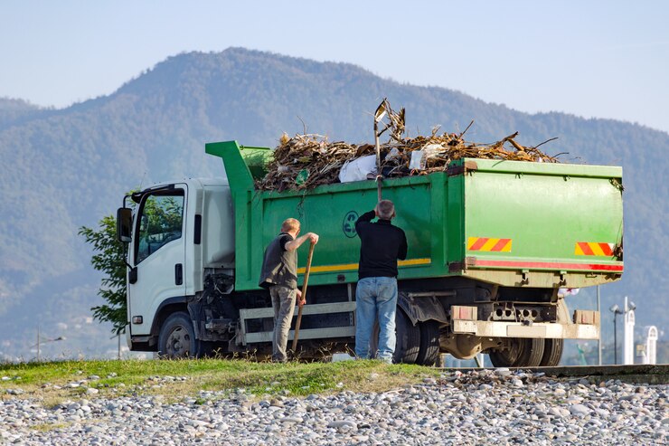 Crew loading a green junk removal truck